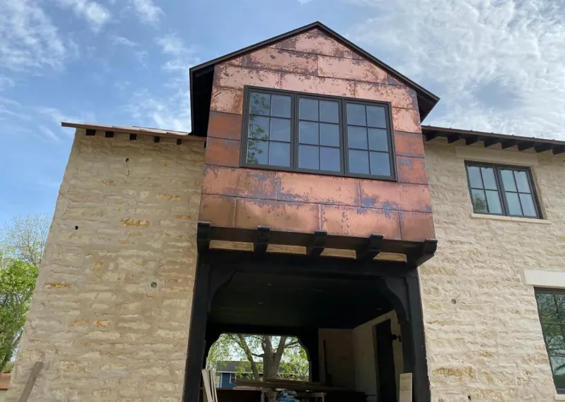 Copper metal panel facade on a stone building for Roof Repair in Hewitt